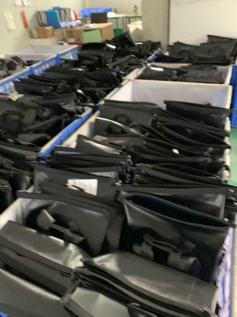 Rows of cloth-lined bins holding finished goods separated by model